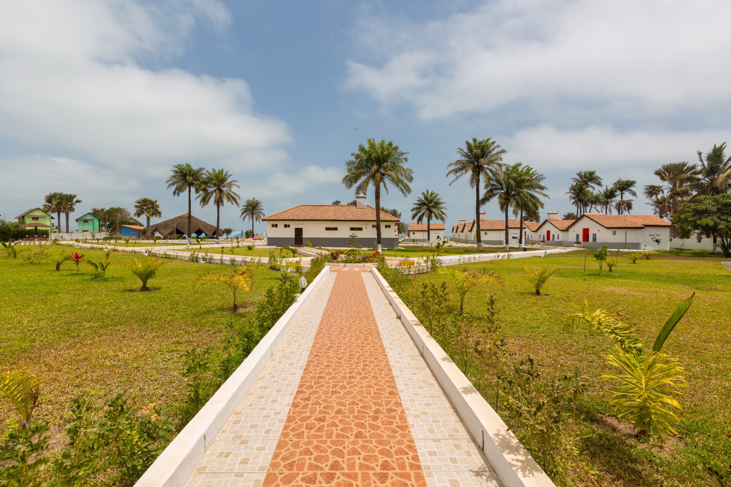 A beautiful pavement and the houses surrounded by grassy fields captured in Gambia, Africa